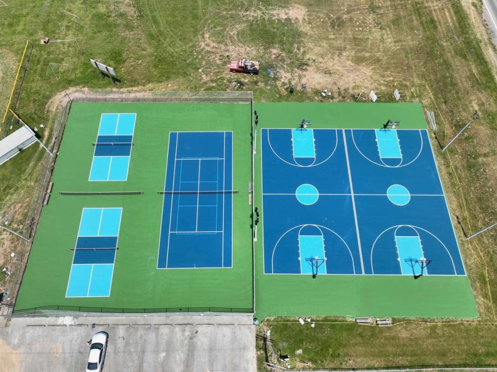 A drone shot shows an aerial view of the completed courts. 