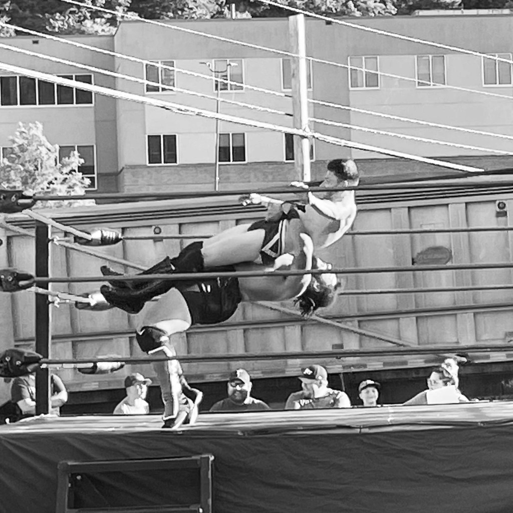 Wrestler Troy Parker takes down an opponent in the ring.