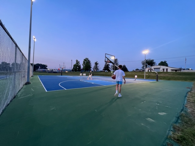 Young men play basketball on the new courts. 
