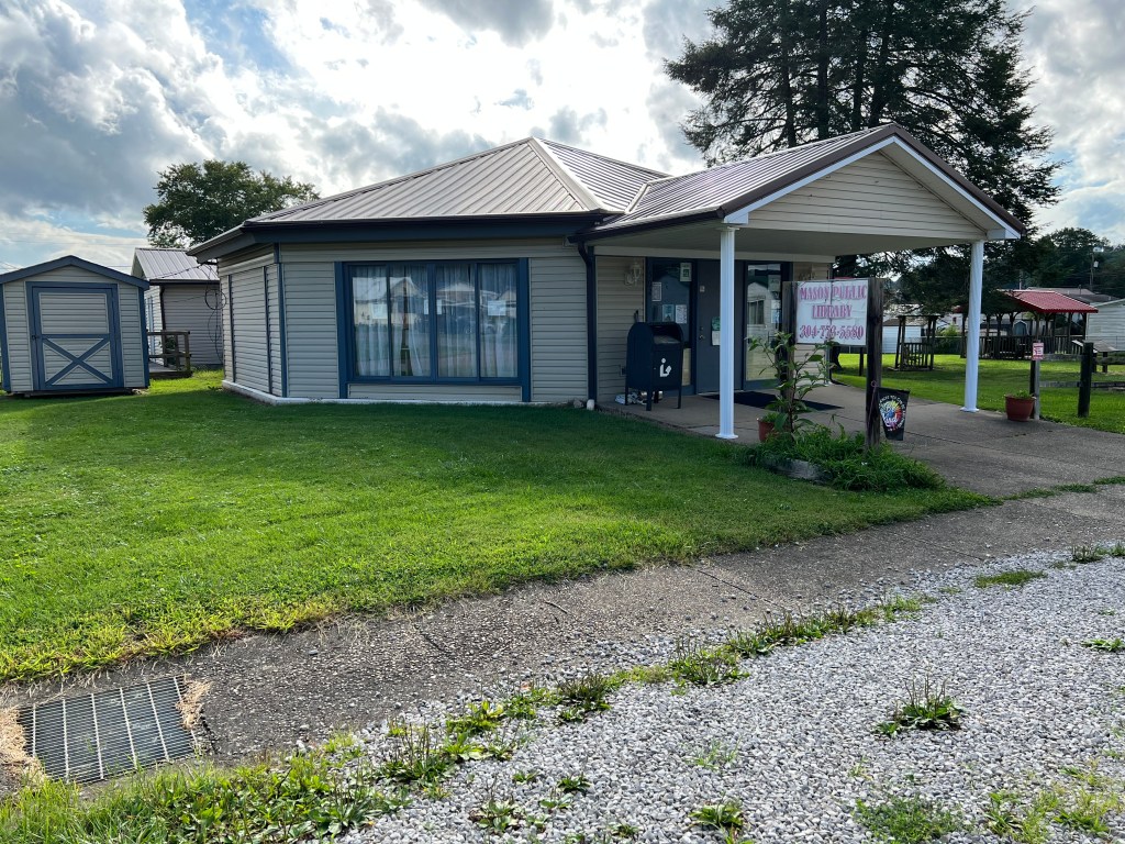 The current library building is pictured along a city street.