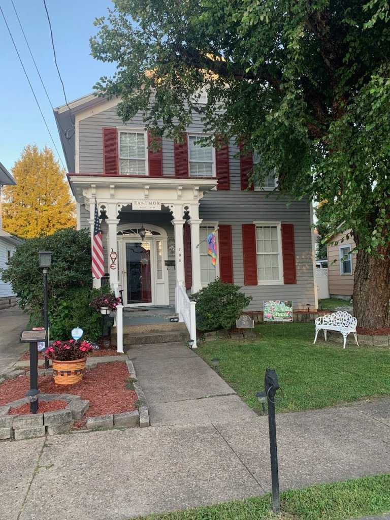 Pictured with a "Yard of the Month" sign, is a decorated yard, with flowers and landscaping surrounding a home. 