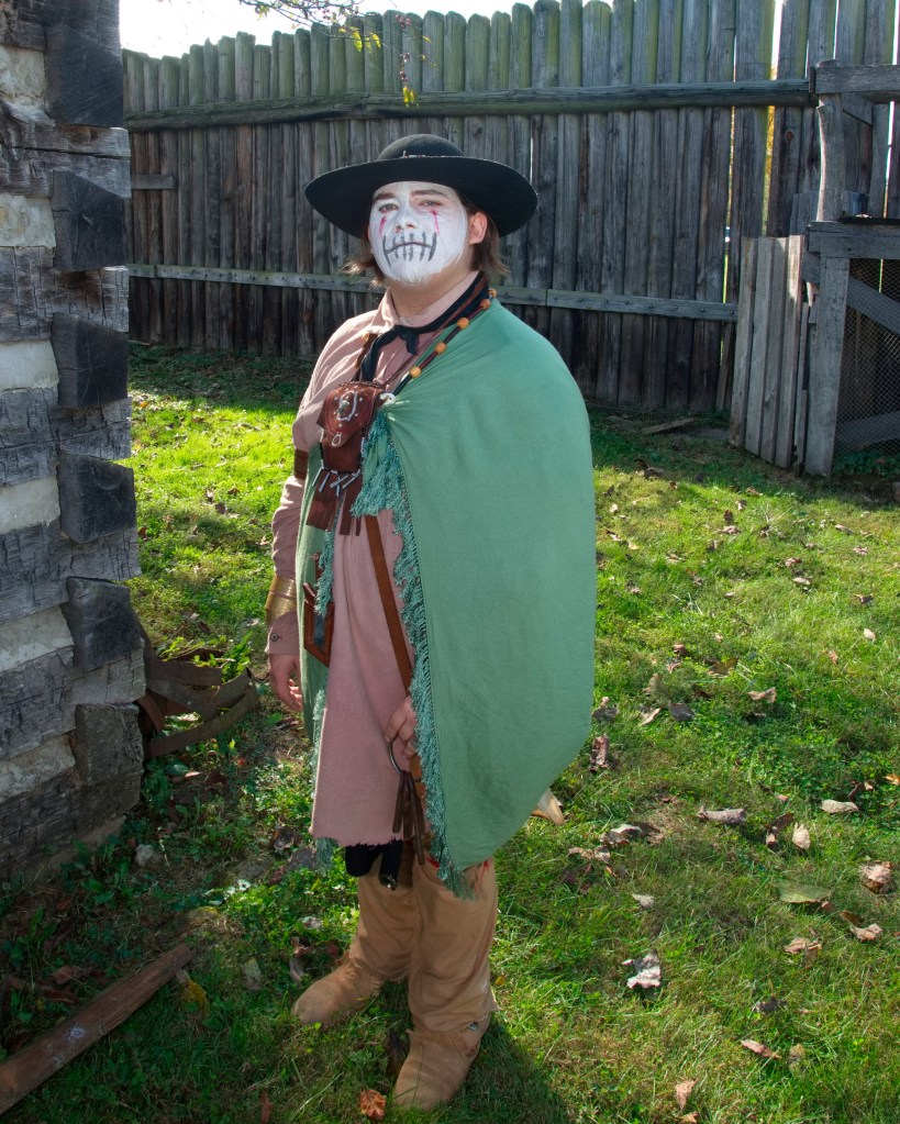 A costumed re-enactor dressed in Colonial garb and compelling, ghostly-white face makeup. 