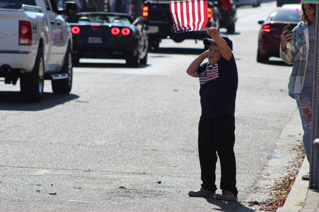 A young boy waves an American Flag along the parade route.