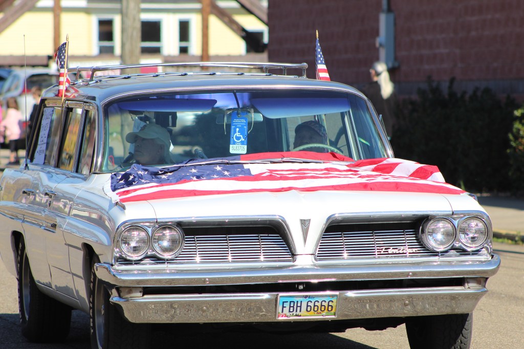 Flag-draped vintage car.