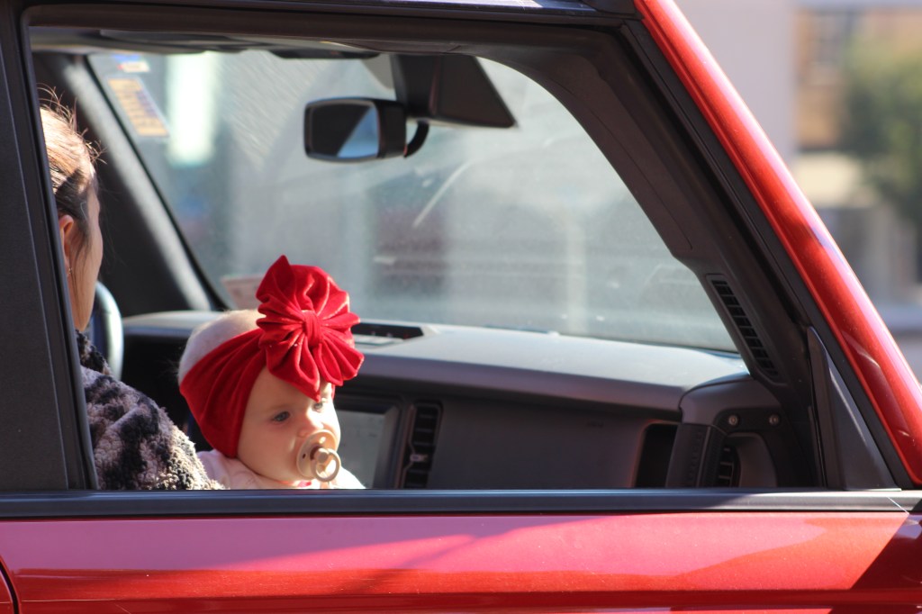 A baby rides along the parade route.