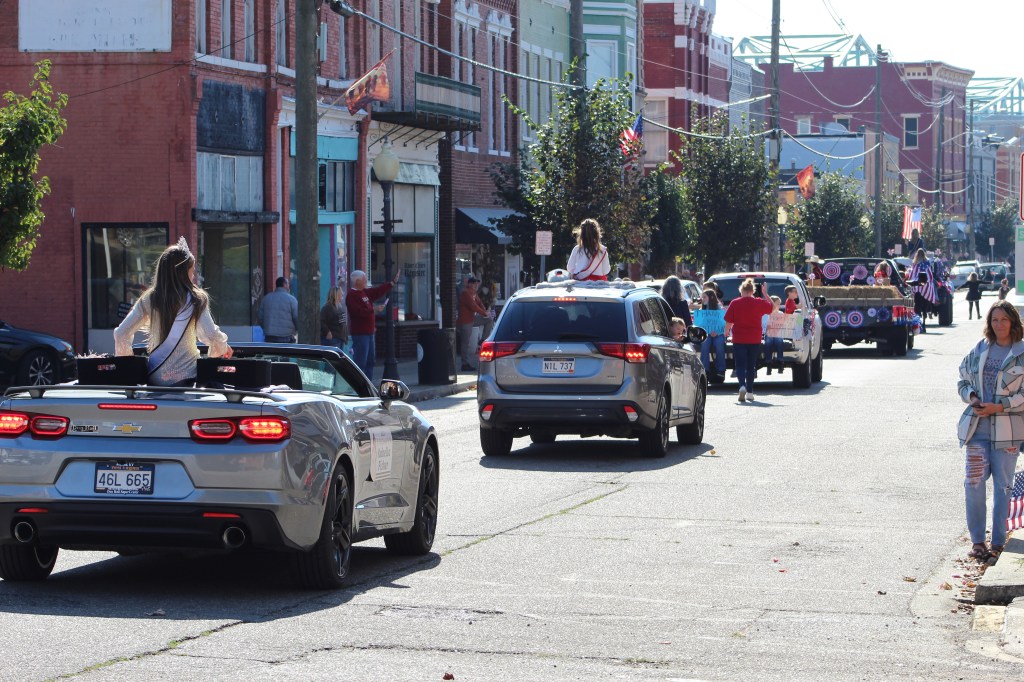A line of cars and floats in the parade.